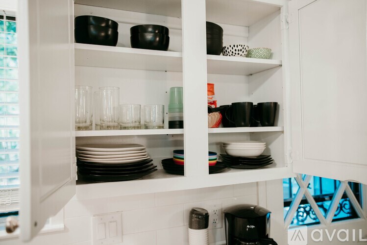 A kitchen cabinet with various dishes and glasses.