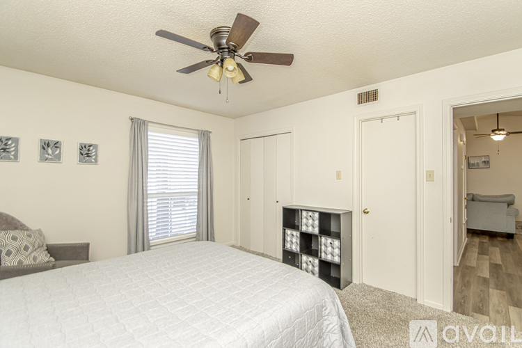 A bedroom with a large bed and a ceiling fan.