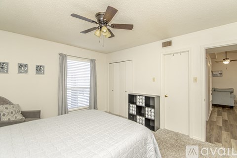 A bedroom with a large bed and a ceiling fan.