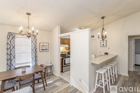 A kitchen area with a dining table and chairs.
