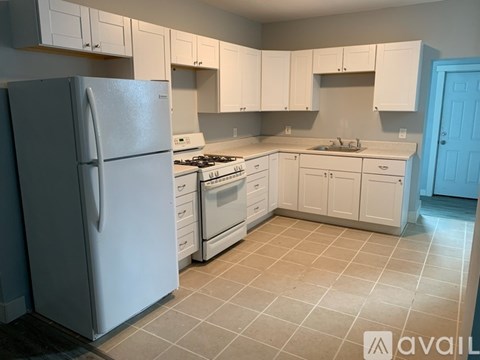 A kitchen with white cabinets and appliances.