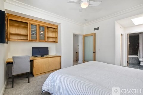 A bedroom with a bed, dresser, and ceiling fan.
