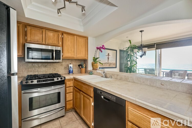 A kitchen with wooden cabinets and a black refrigerator.
