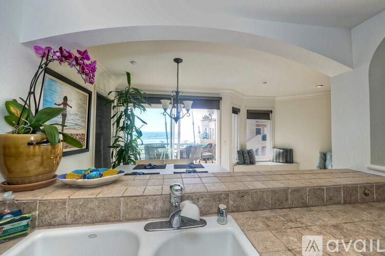 A kitchen with a sink and a painting of a woman on the wall.