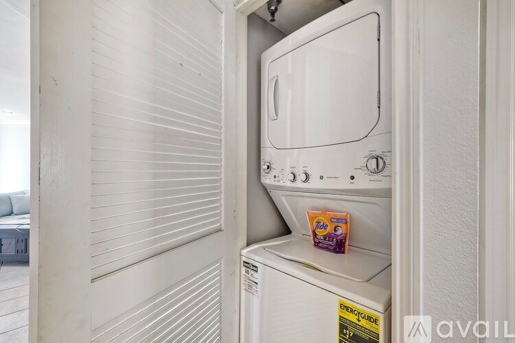 A dining room with a table set for six with a view of the kitchen.