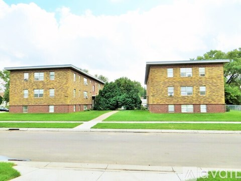 Two identical brick apartment buildings sit side by side.