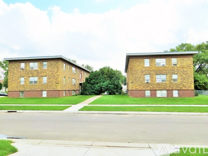 Two identical brick apartment buildings sit side by side.