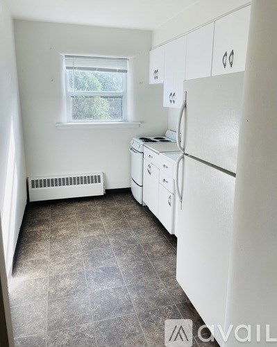 A kitchen with white appliances and a window.
