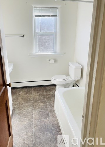 A bathroom with a toilet, sink, and tub.