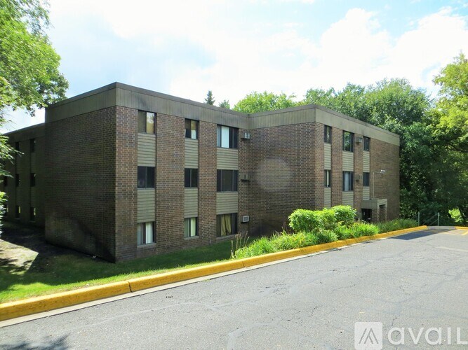 A large brick building with a parking lot in front.