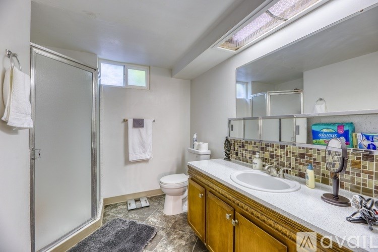 A bathroom with a toilet, sink, and shower.