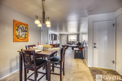 A dining room with a wooden table and chairs.