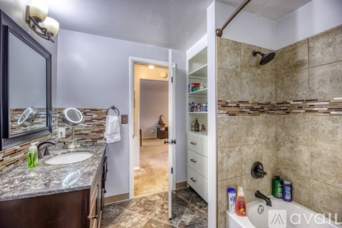 A bathroom with a shower, sink, and mirror.