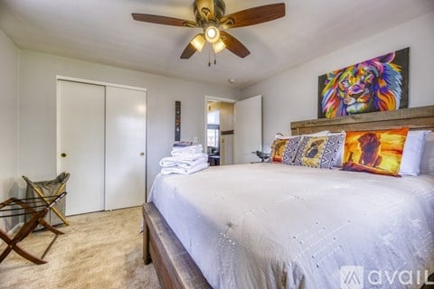 A bedroom with a large bed and a ceiling fan.