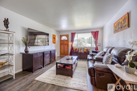 A living room with a brown leather couch and a wooden coffee table.