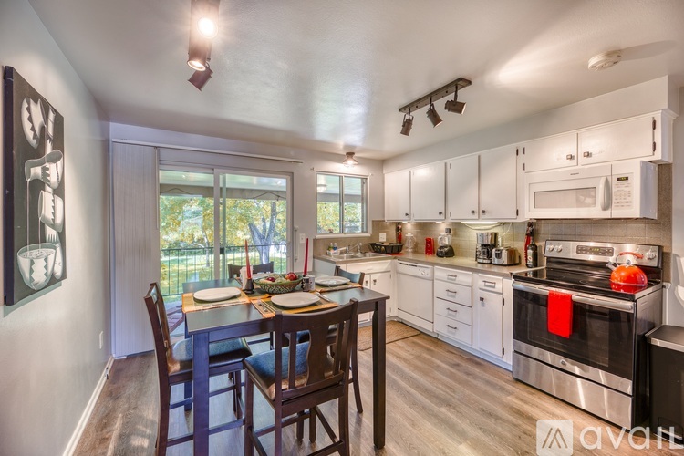 A kitchen with a dining table and chairs.