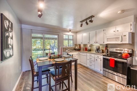 A kitchen with a dining table and chairs.