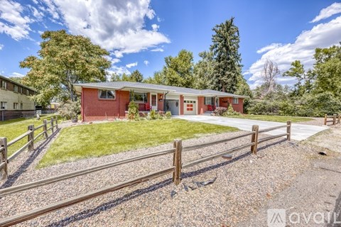 A red house with a white fence in front of it.