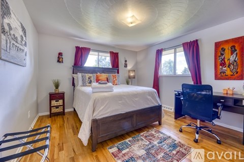 A bedroom with a bed, desk, and chair.