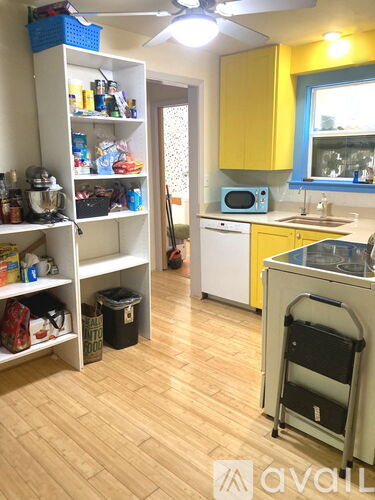 A kitchen with yellow cabinets and a white fridge.