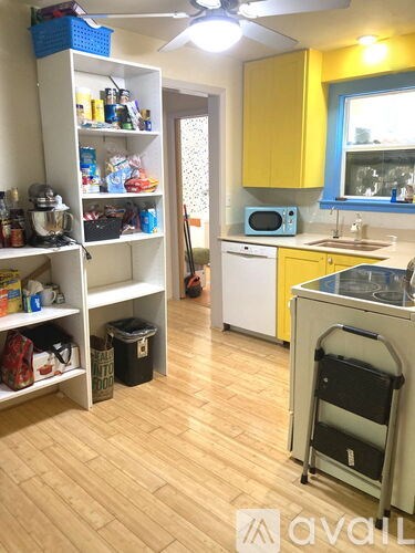A kitchen with yellow cabinets and a white fridge.