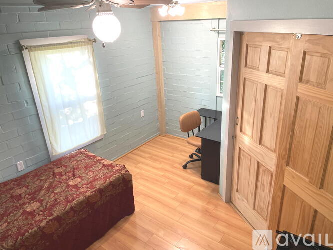 A bedroom with a bed, a fan, and a closet.