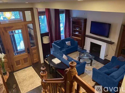 A living room with a blue couch and a fireplace.
