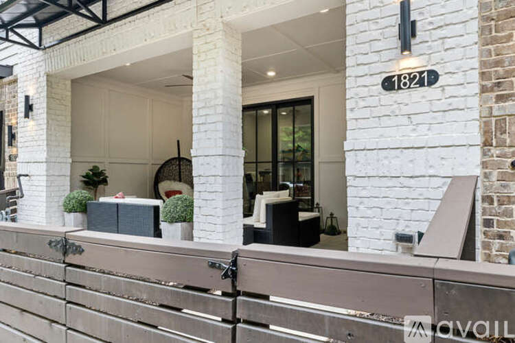 A modern house with a white brick wall and a black metal railing.