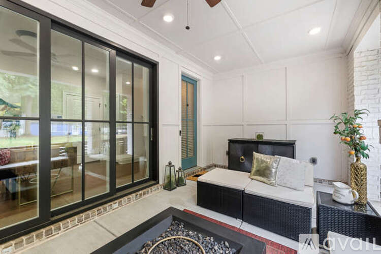 A modern bedroom with a black bed and a glass door leading to a balcony.