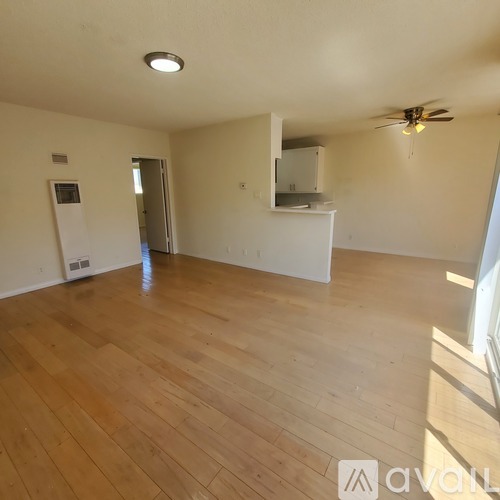 A room with wooden flooring and a ceiling fan.