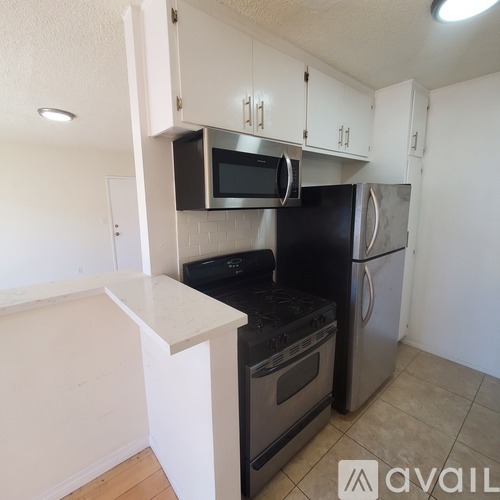 A kitchen with black appliances and white cabinets.