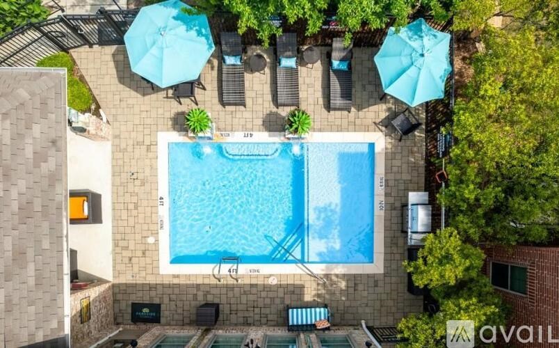 An aerial view of a pool surrounded by lounge chairs and umbrellas.