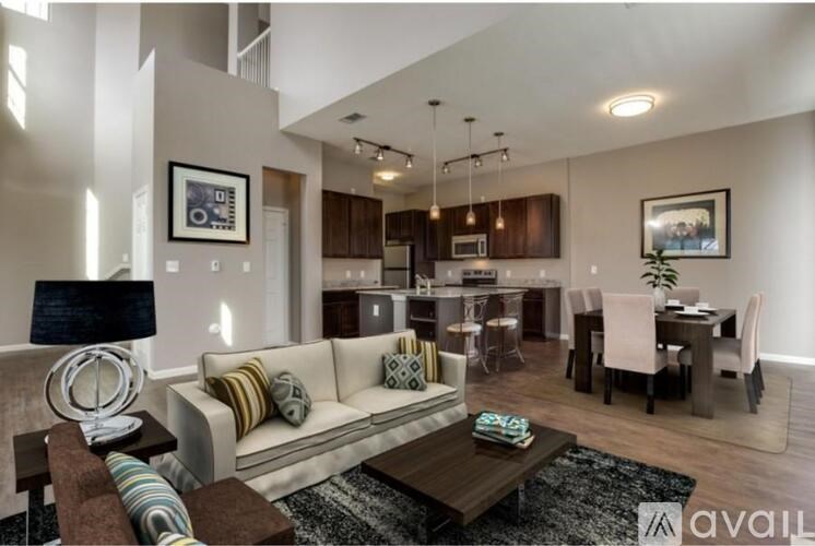 A modern living room with a white sofa, a coffee table, and a dining area in the background.
