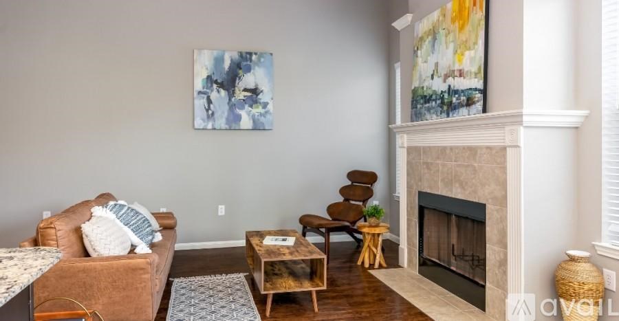 A living room with a fireplace and a painting on the wall.