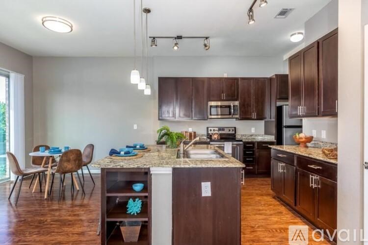 A kitchen with brown cabinets and a granite countertop.