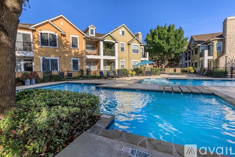 A pool surrounded by apartment buildings with a "NO DIVING" sign.