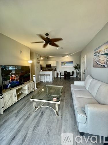 A living room with a glass coffee table and a white couch.