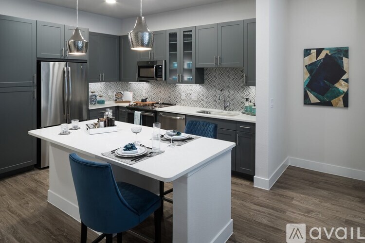 A modern kitchen with a dining table set for two.