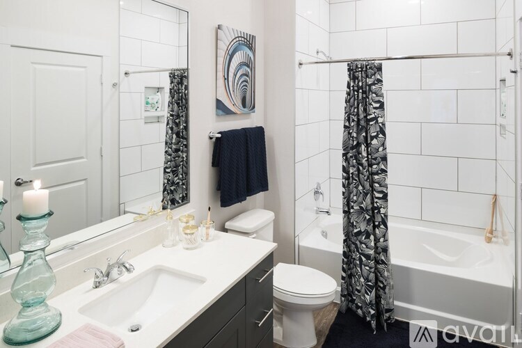 A bathroom with a white toilet, a white sink, a white bathtub, and a white shower curtain.