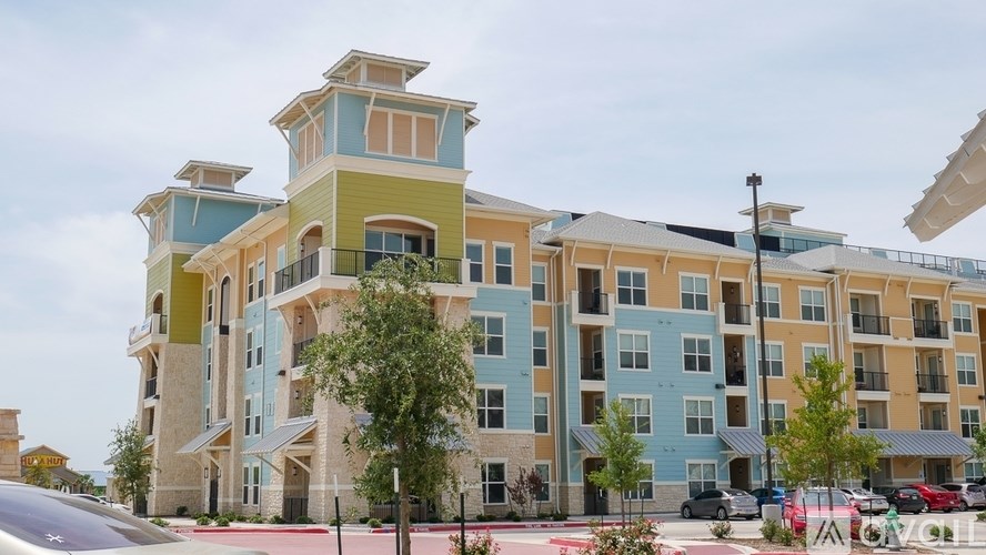 A modern apartment building with balconies and multiple stories.