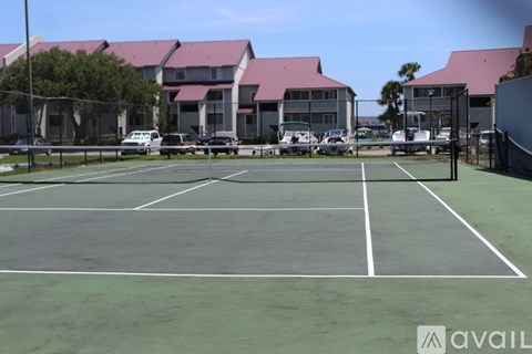 A tennis court with a building in the background.