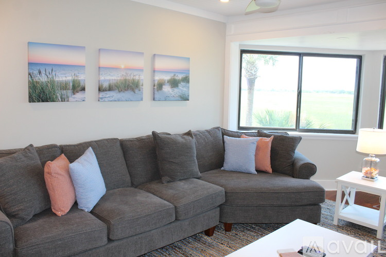 A living room with a grey couch and a white coffee table.