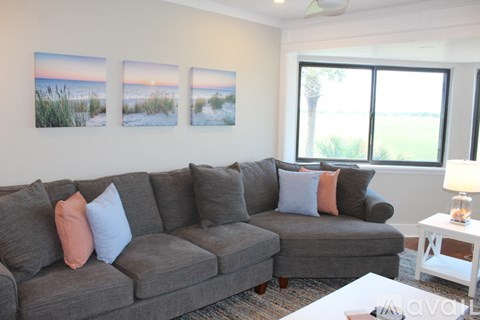 A living room with a grey couch and a white coffee table.