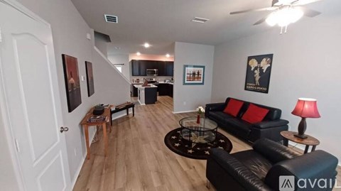 A living room with a black couch and a coffee table.