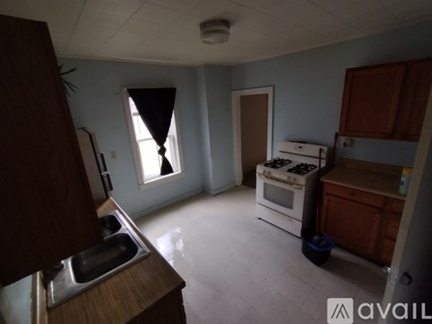 A kitchen with a stove, sink, and cabinets.