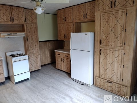 A kitchen with wooden cabinets and a white refrigerator.