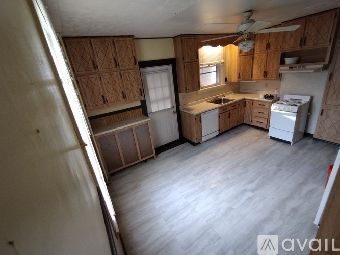 A kitchen with wooden cabinets and a white stove top oven.