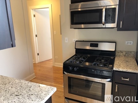 A kitchen with a stove and microwave above it.