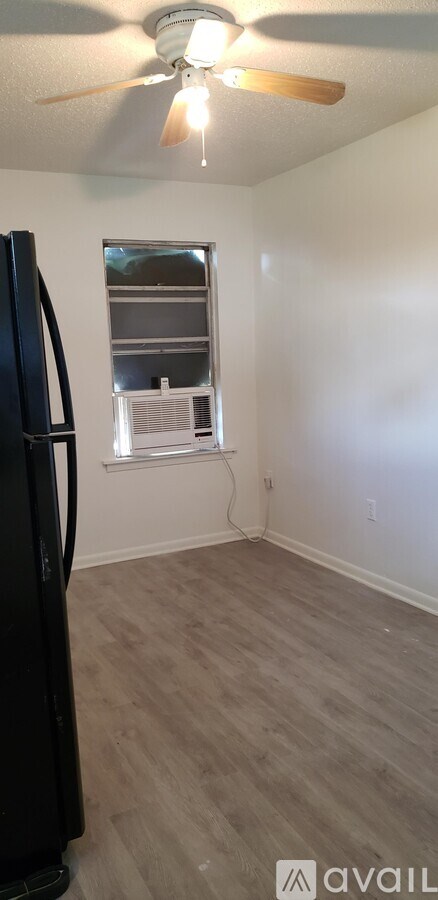 A room with a ceiling fan and a window with blinds.