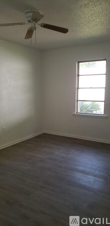 A room with a ceiling fan and a window.